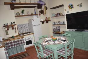 cocina con mesa con sillas y TV en Corte Magnano, en Ragalna
