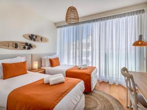 Una habitación de hotel con dos camas y una ventana. en Bayline - Beachfront Bliss & Spa by Bedzy, en Armação de Pêra 68 fotos más
