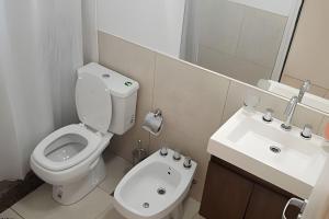 a white bathroom with a toilet and a sink at Hornera Lagos - Moderno, amplio y luminoso in Rosario