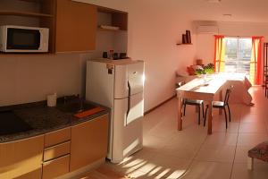 a kitchen with a white refrigerator and a table at Hornera Lagos - Moderno, amplio y luminoso in Rosario