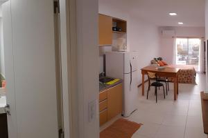 uma cozinha com uma mesa e um frigorífico branco em Hornera Lagos - Moderno, amplio y luminoso em Rosário