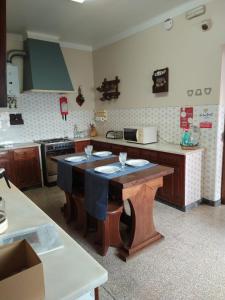 eine Küche mit einem Tisch in der Mitte in der Unterkunft Casa da Adega in Quinta do Anjo