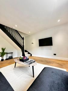 a living room with a table and a tv on the wall at Canal Mews in Manchester