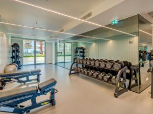 un gimnasio con filas de pesas en una habitación en Bayline - Beachfront Bliss & Spa by Bedzy, en Armação de Pêra
