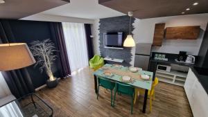 a kitchen and living room with a table and chairs at Lux Apartment Modern in Polanica-Zdrój