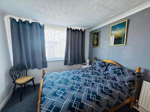 a bedroom with a blue and white bed and a window at Lynalan Hotel in Blackpool