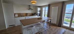 a kitchen with a island with stools and a counter top at LES APPARTS KENNEDY in Le Havre