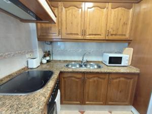 a small kitchen with a sink and a microwave at Casa Soledad in Vejer de la Frontera