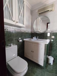 a bathroom with a toilet and a sink and a mirror at Casa Soledad in Vejer de la Frontera