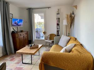 een woonkamer met een bank en een tafel bij Villa au calme dans un domaine boisé in La Motte