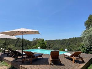 een terras met stoelen en een zwembad bij Villa au calme dans un domaine boisé in La Motte