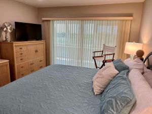 1 dormitorio con 1 cama, TV y silla en 1200-602 Enjoy Relaxing Bayfront Bliss, en Sarasota