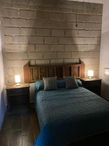 1 dormitorio con 1 cama con 2 mesitas de noche y 2 lámparas en Hostal Doña Cuca en Capilla de Guadalupe