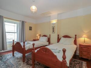 a bedroom with two beds and a window at Cathay House in Cheddar