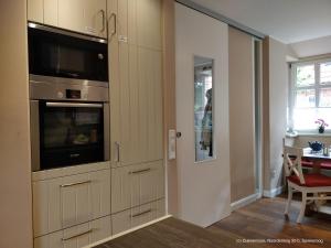 a kitchen with a built in oven and a microwave at Dünenrose in Spiekeroog +23 photos