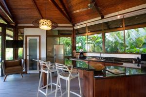 a kitchen with a counter and chairs in a room at Tulemar Resort in Manuel Antonio