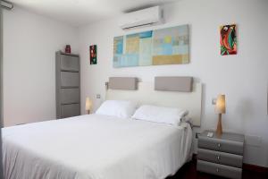 Dormitorio blanco con cama blanca y pared blanca en Casa Molinar, en Palma de Mallorca