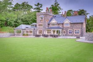 a large stone house with a green lawn at The Manor Boutique Hotel Restaurant and Bar in Conwy