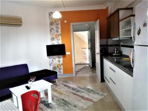 uma cozinha com um sofá e uma mesa num quarto em Maya Apart Antalya em Antalya