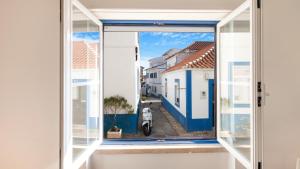 an open window with a view of a street at Ericeira 2BDR Coastal Escape by LovelyStay in Ericeira