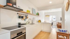 a white kitchen with a sink and a stove at Ericeira 2BDR Coastal Escape by LovelyStay in Ericeira