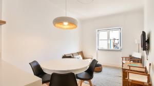 a dining room with a white table and chairs at Ericeira 2BDR Coastal Escape by LovelyStay in Ericeira