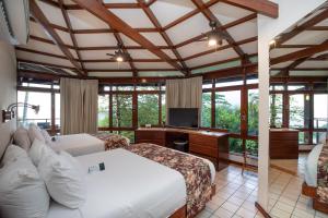 a hotel room with two beds and a television at Tulemar Resort in Manuel Antonio