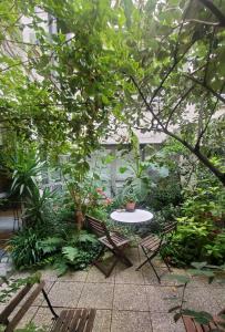 d'une terrasse avec une table et des chaises dans le jardin. dans l'établissement Une chambre à Paris 20eme avec un petit jardin, à Paris