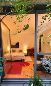 - une chambre avec un lit et une grande fenêtre en verre dans l'établissement Une chambre à Paris 20eme avec un petit jardin, à Paris