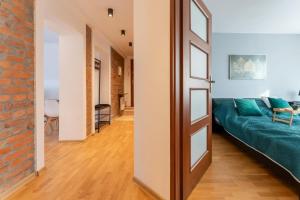 a living room with a green couch and a brick wall at Apartament RatuszLove - 2 osobne sypialnie, z widokiem na Ratusz - by SpaceApart in Jelenia Góra