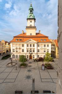 a large building with a clock tower on top of it at Apartament RatuszLove - 2 osobne sypialnie, z widokiem na Ratusz - by SpaceApart in Jelenia Góra