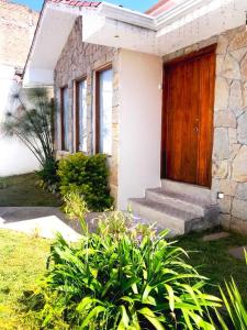 a house with a wooden door and some plants at Vive con nosotros tusvacaciones in Cuenca