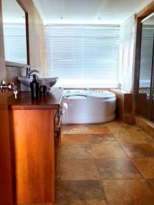 a large bathroom with a tub and a sink at Vive con nosotros tusvacaciones in Cuenca