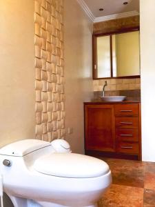 a bathroom with a white toilet and a sink at Vive con nosotros tusvacaciones in Cuenca