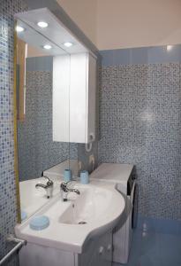 bagno con lavandino bianco e specchio di Templum Iovis a Civitavecchia