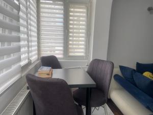 a room with a table and chairs and a couch at Carlitos apt in Râmnicu Vâlcea