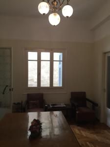 a dining room with a table and two chairs and a chandelier at Relax & Enjoy in Athens