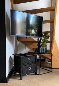 Un televisor sobre un soporte negro con una cómoda negra. en House of Nature, en Radawka