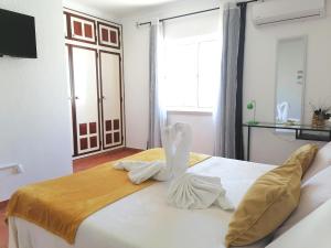 a bedroom with a bed with a swan decoration on it at Marreiro's house Algarve - Child friendy - Private Pool in Lagos