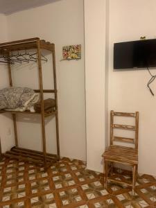 a room with a bunk bed and a chair at Pouso nossa senhora das merces in Tiradentes