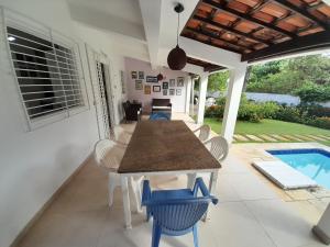 a dining room with a table and chairs and a pool at Casa em Porto de Galinhas in Porto De Galinhas