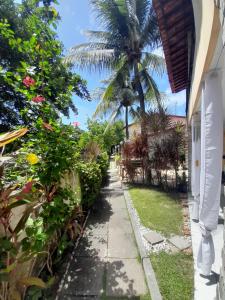a walkway to a house with a palm tree at Casa em Porto de Galinhas in Porto De Galinhas