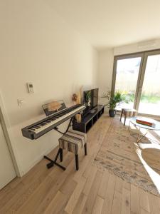 - un salon avec un piano et une télévision dans l'établissement Appartement de Standing avec jardin, à Clamart