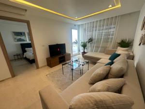 a living room with a couch and a television at Cosy appartement in La Marsa
