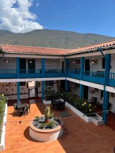 ein Apartmenthaus mit einer Terrasse mit Tischen und Stühlen in der Unterkunft Celeste Villa de Leyva in Villa de Leyva