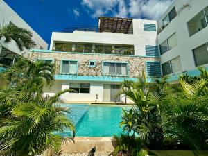 a building with a swimming pool in front of a building at Rosa Azul Tulum in Tulum