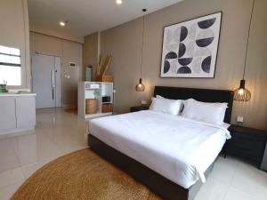 a bedroom with a large white bed and a kitchen at City View Studio Unit in Phnom Penh