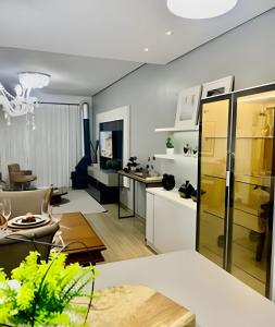 a living room with a kitchen and a dining room at Apto Apaixonante com Piscina Aquecida 4min centro in Gramado