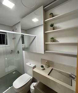 a bathroom with a toilet and a sink at Apto Apaixonante com Piscina Aquecida 4min centro in Gramado