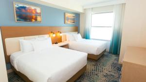 a hotel room with two beds and a window at Holiday Inn Club Vacations Myrtle Beach Oceanfront in Myrtle Beach